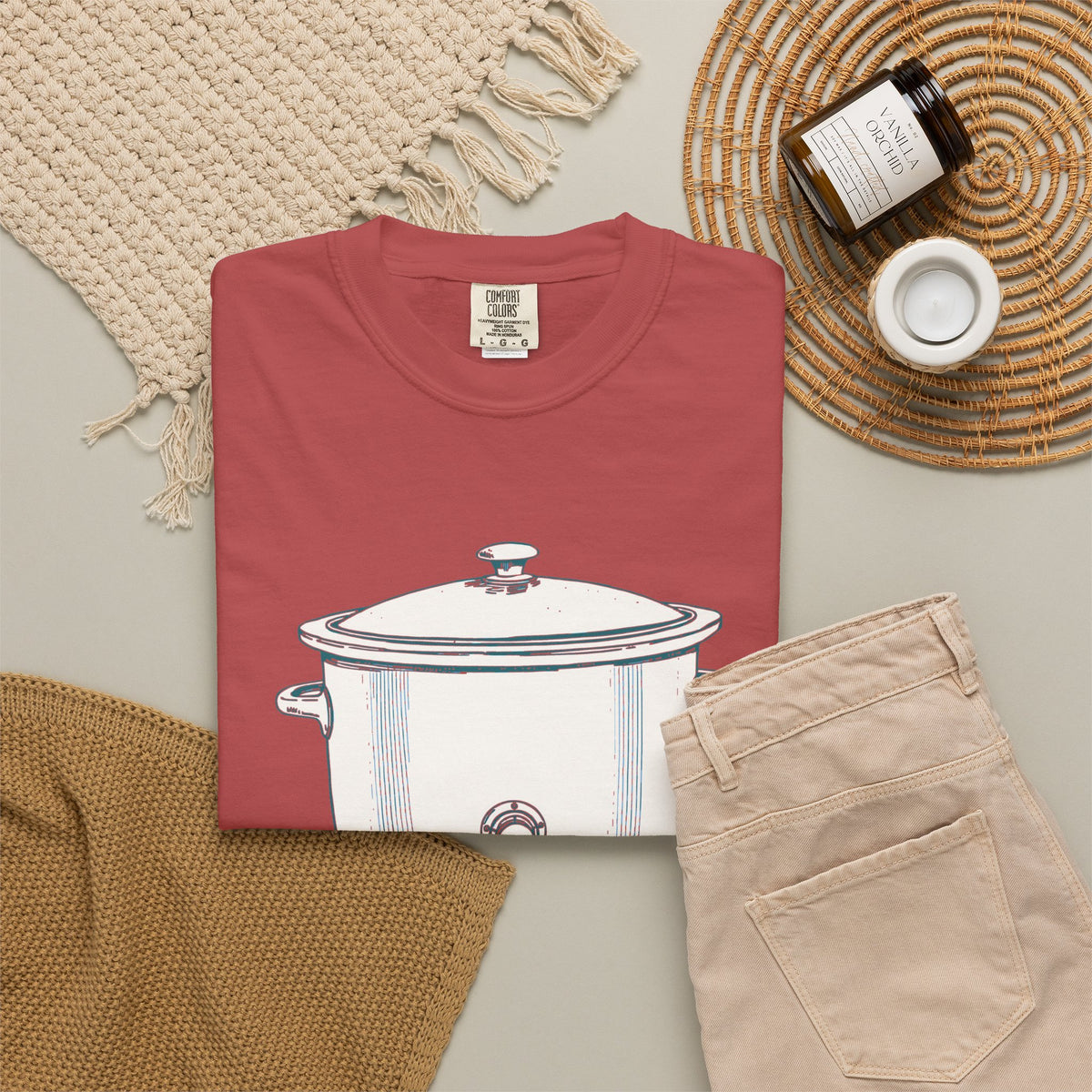 I Have Feelings I'm Processing Them Slowly tee in Crimson, folded in a styled flat lay with a woven mat, candle and khaki shorts — slow cooker print on the front