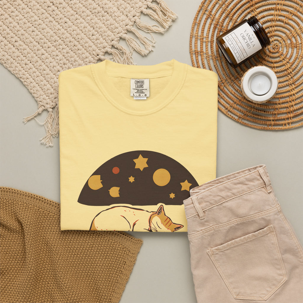 Lunch Break Read tee in Butter yellow, folded in a styled flat lay with a woven mat, candle and khaki shorts — sleeping cat print on the front