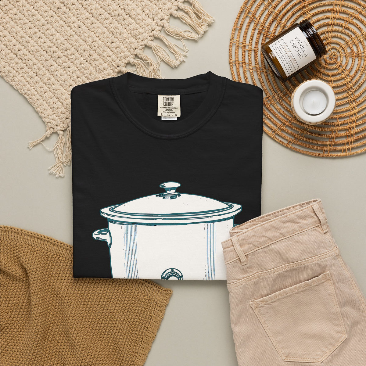 I Have Feelings I'm Processing Them Slowly tee in Black, folded in a styled flat lay with a woven mat, candle and khaki shorts — slow cooker print on the front