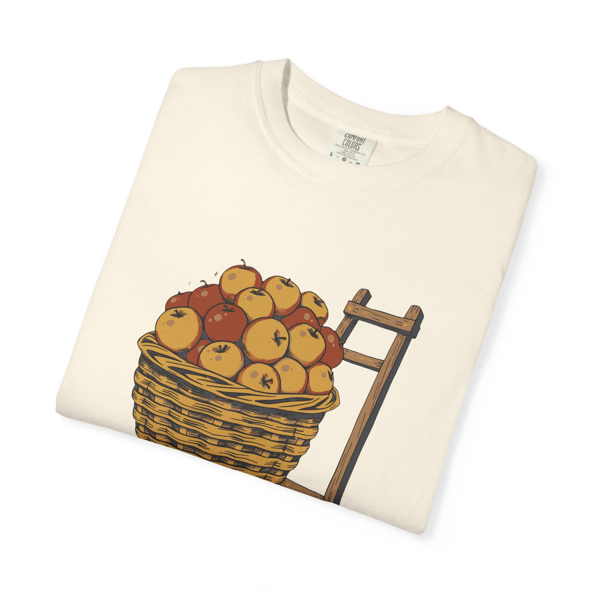 Peaked in the Orchard tee in Ivory, folded — close view of the apple basket print