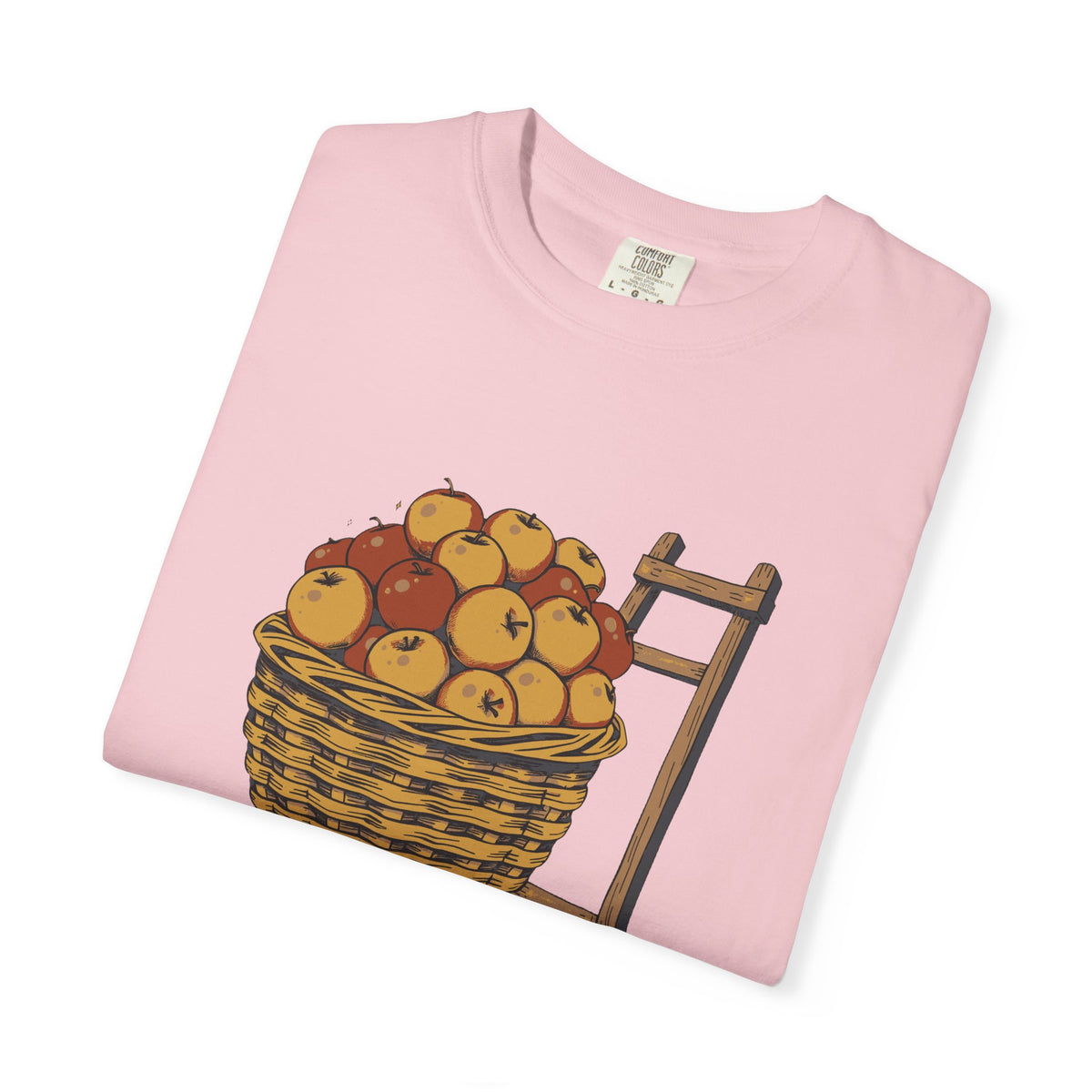 Peaked in the Orchard tee in Blossom pink, folded — close view of the apple basket print